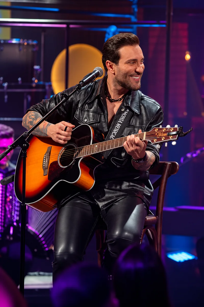 Bruno César cantando com violão no palco